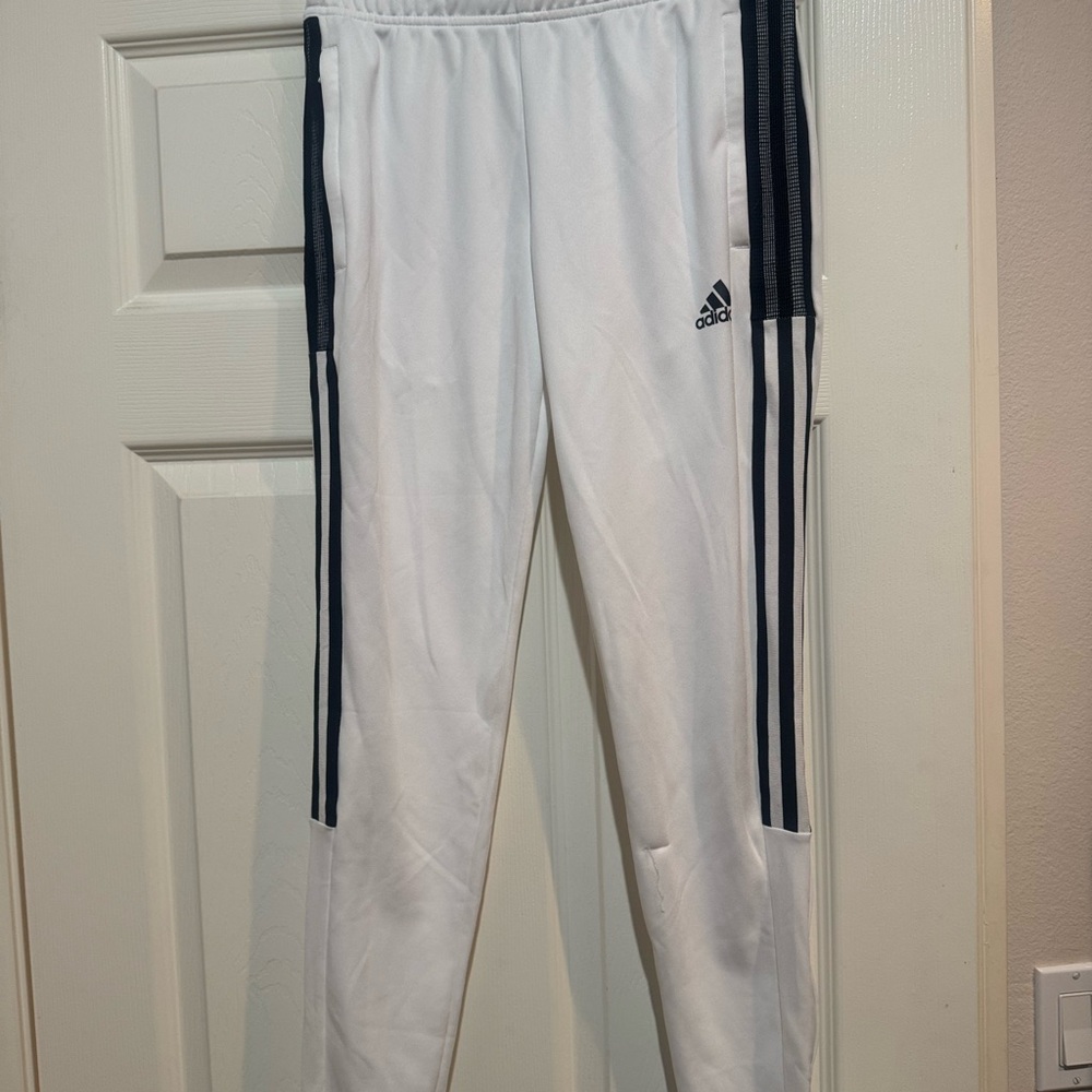 Adidas Women's White Joggers with black stripes.